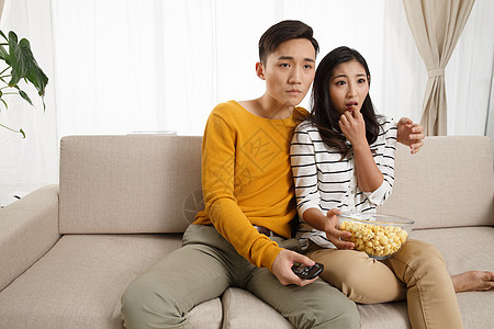 乐趣亚洲健康的青年情侣坐着沙发上看电视图片