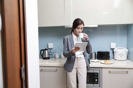 办公青年女人在厨房使用平板电脑图片