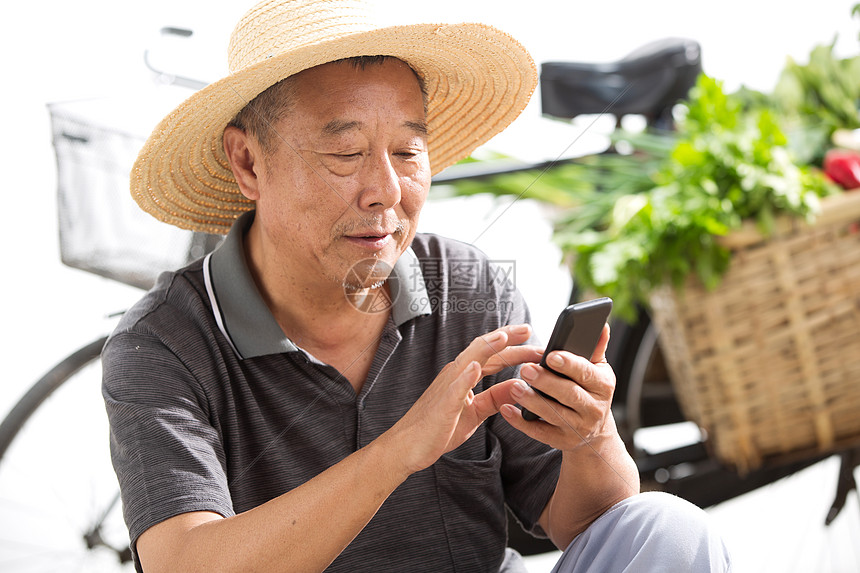 收获老农民拿着手机图片