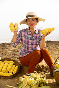 坐在地上中年女人拿着玉米图片