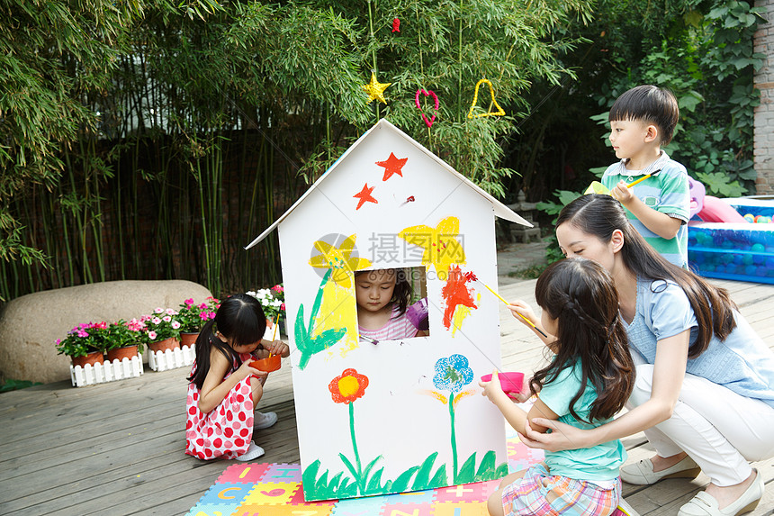 青年女人蹲亚洲人幼儿园的师生在做手工图片