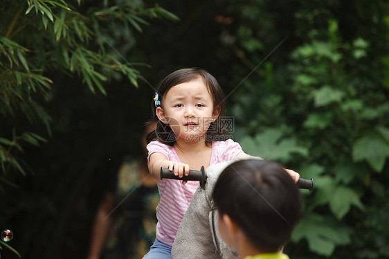 休闲装童年冒险可爱的小女孩在骑摇摆木马图片