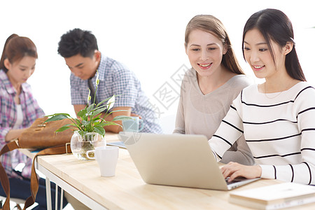西方女性东亚知识青年年轻的大学生在使用电脑背景