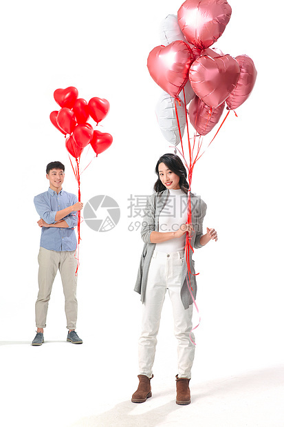 女人注视镜头全身像浪漫情侣拿着心形气球图片