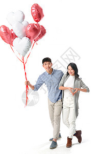 休闲装庆祝青年女人浪漫情侣拿着心形气球图片