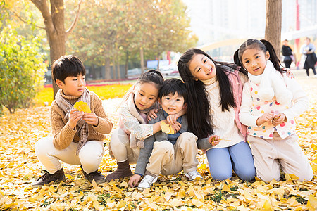 小学生落叶朋友可爱的男孩女孩在户外玩耍图片