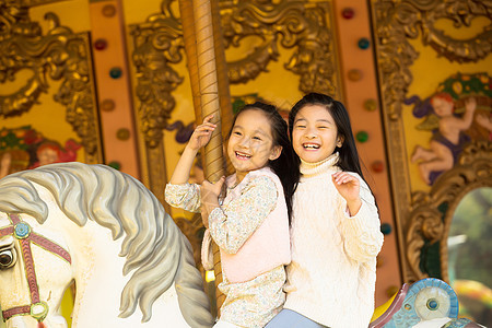 表现积极活力秋天两个小女孩在玩旋转木马图片