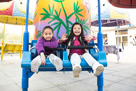 亚洲公园娱乐两个女孩在游乐场玩耍图片