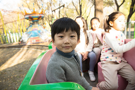 伙伴公园兴奋男孩女孩坐在游乐场玩耍图片