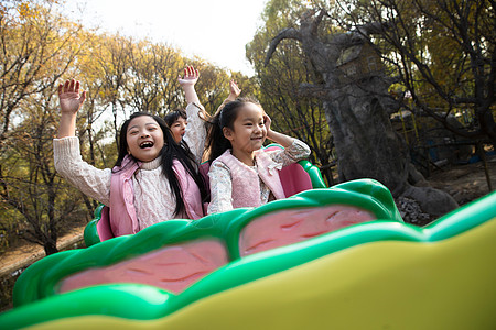 游乐园亲子可爱的小学生学龄儿童男孩女孩坐过山车背景