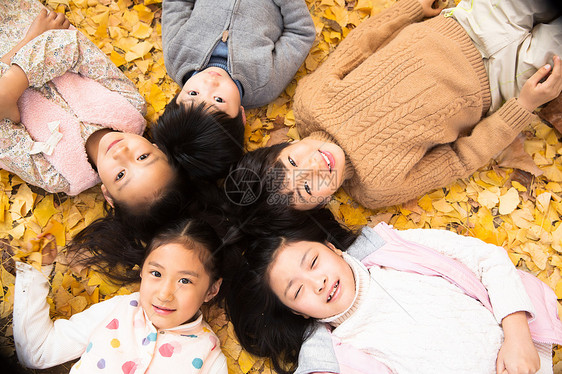 挨着亚洲小学生可爱的男孩女孩躺在地上图片