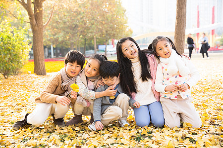 欢乐落叶相伴可爱的男孩女孩在户外玩耍图片