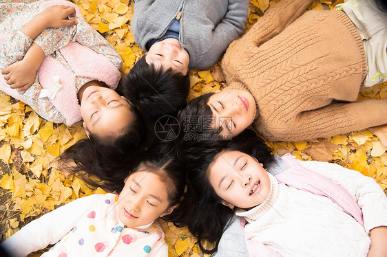 快乐童年东亚可爱的男孩女孩躺在地上图片