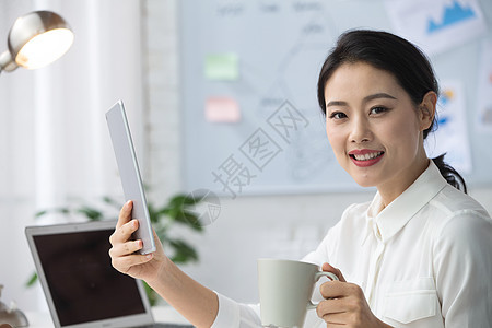 现代户内ipad青年商务女人使用平板电脑办公图片