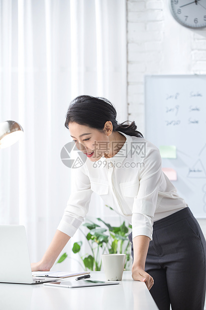 青年商务女人使用笔记本电脑办公图片