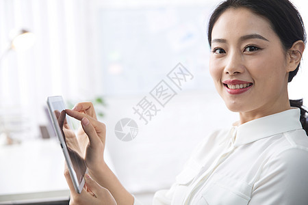 白昼办公室职员东亚青年商务女人使用平板电脑办公图片