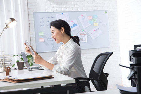 使用ipad办公室职员青年商务女人使用平板电脑办公背景