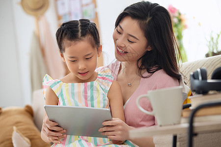 相伴儿童年轻家庭快乐母女在家看平板电脑图片
