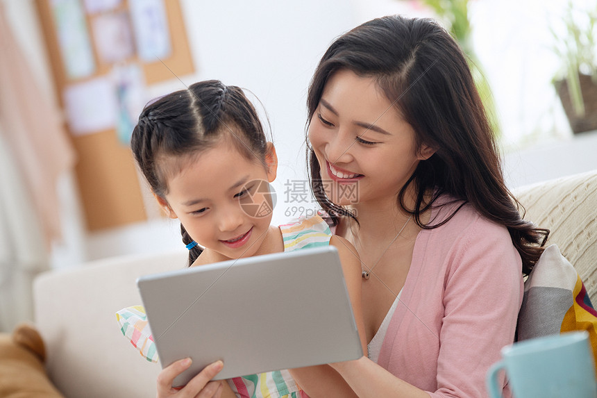 20多岁亚洲快乐母女在家看平板电脑图片