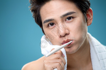 年轻男人用毛巾擦刷牙时脸上的泡沫图片
