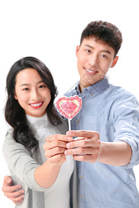 青年伴侣前景聚焦展示浪漫情侣拿着棒棒糖图片