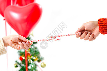 圣诞条纹满意节日乐趣青年情侣拿着拐杖糖背景