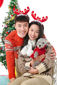 抱着宠物狗的青年情侣过圣诞节图片