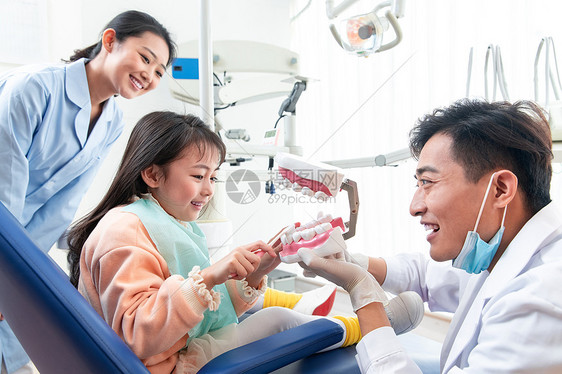 牙科医生教小女孩刷牙图片