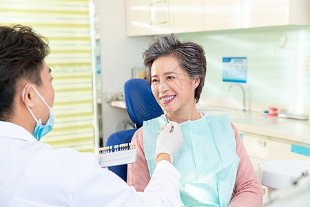 身体关注25岁到29岁亚洲牙医和老年患者交谈图片