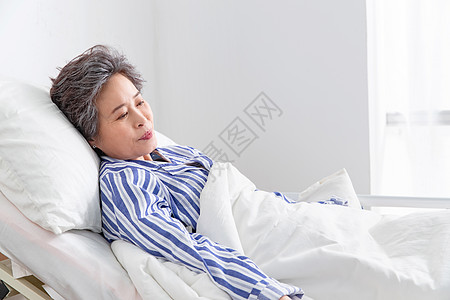 窗户户内50多岁老年患者坐在医院病床上图片