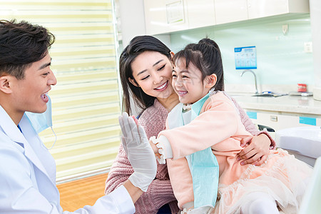 年轻妈妈带着小女孩看牙医背景图片