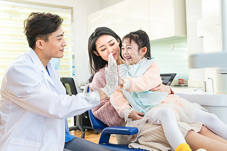 年轻妈妈带着小女孩看牙医背景图片