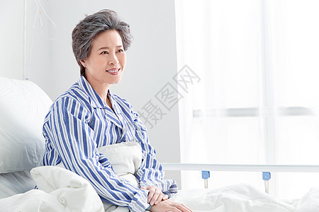 生病摄影老年患者坐在医院病床上图片
