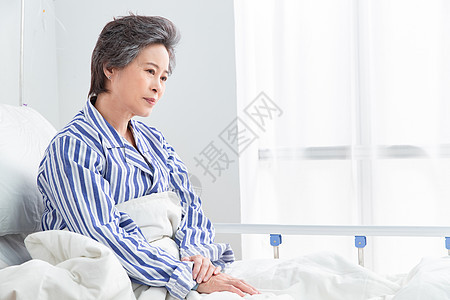 悲哀50多岁病房老年患者坐在医院病床上图片