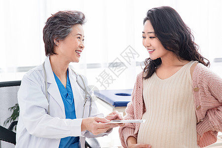 孕妇和医生关爱东亚表现积极医生给孕妇检查身体背景