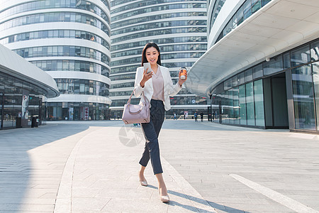 全身像通讯饮食拿着咖啡的商务女看手机图片