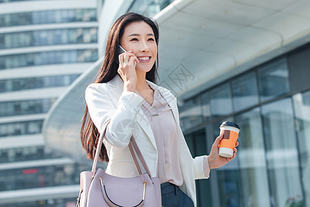 努力青年女人拿着咖啡的商务女打电话图片