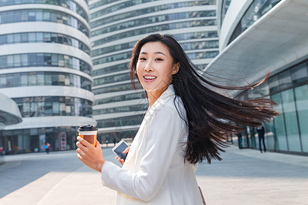 北京望京soho拿着咖啡杯的快乐商务女士背景