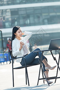 一次杯子使用电脑青年人青年商务女士在户外工作图片