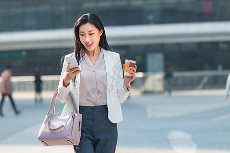 精力不看镜头女商人青年商务女人边走边看手机图片