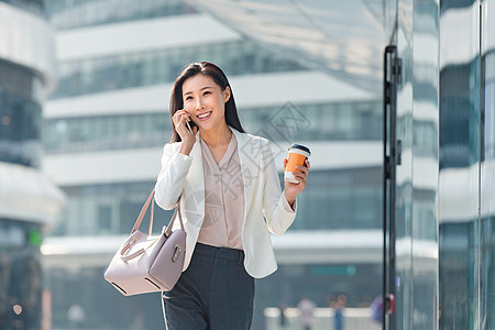 通勤者饮食商业区青年商务女人边走边打电话背景图片