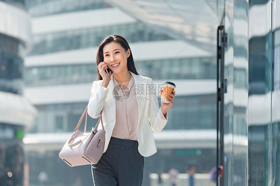 通勤者饮食商业区青年商务女人边走边打电话图片