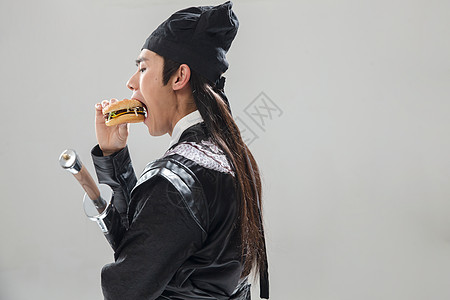 武术历史服装有趣的吃汉堡的青年男人图片
