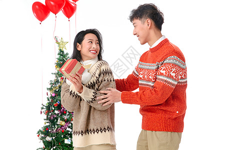 不看镜头圣诞装饰物浪漫青年男人送女朋友圣诞礼物图片