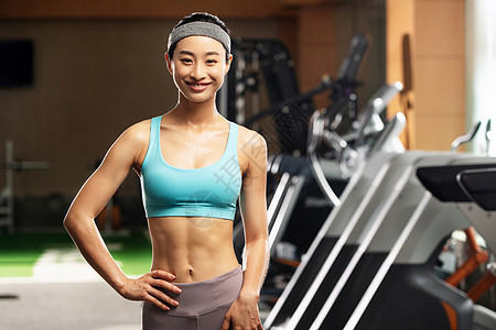 器材健身青年女人在健身房背景