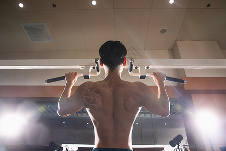 展示肱二头肌青年男人在健身房健身图片