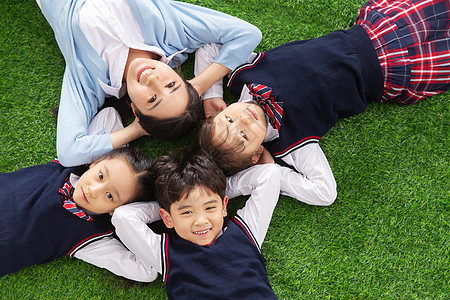 女孩躺在草地上小学生们躺在草地上背景