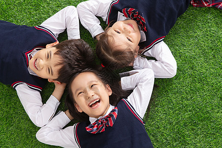 高视角东方人6岁到7岁小学生们躺在草地上图片