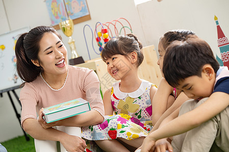 青年人同学女孩幼儿园老师给小朋友们讲故事图片