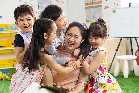 早期教育青年女人幼儿园老师和小朋友们拥抱在一起图片